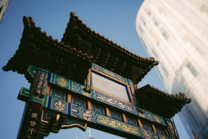 A vibrant Chinese archway in England against a modern building.