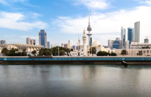 Scenic view of Kuwait City skyline featuring Liberation Tower and waterfront under a clear sky.
