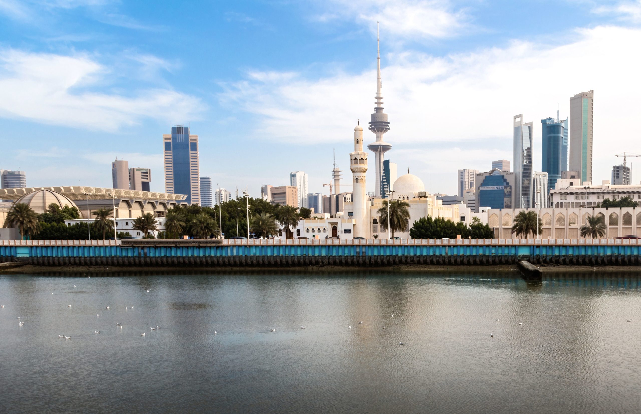Scenic view of Kuwait City skyline featuring Liberation Tower and waterfront under a clear sky.